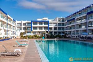 a swimming pool in front of a large building at Beach & Pool - Adan Beach in Aourir