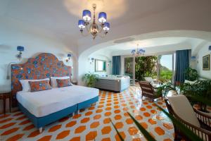 a bedroom with a bed and a tub and a chandelier at Hotel Pellegrino in Praiano