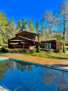 ティグレにあるSweet Home 4のログハウスで、目の前にスイミングプールがあります。