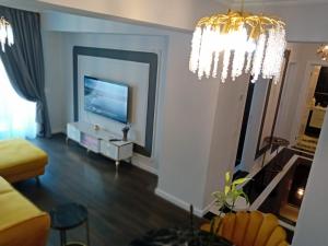 un soggiorno con un divano e una televisione di Exquisite Prima a Oradea Altre 29 foto