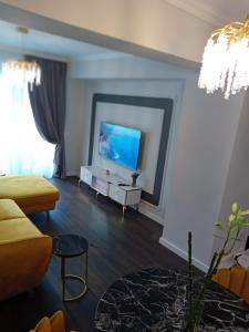 un soggiorno con divano e TV a schermo piatto di Exquisite Prima a Oradea