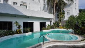ein Schwimmbad vor einem Gebäude in der Unterkunft Adrian's Place at La Bella Tagaytay in Galicias