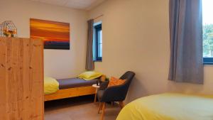 a room with two beds and a chair in it at Vakantiewoning De Schuur Tienen in Tienen