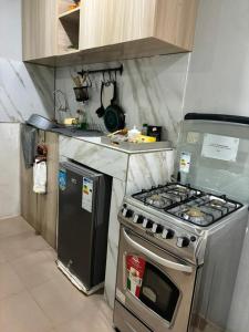 a kitchen with a stove and a refrigerator at Residence Cloé in Ouagadougou