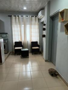 a living room with chairs and a table at Residence Cloé in Ouagadougou +3 photos