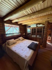 a bedroom with a large bed in a log cabin at Sweet Home 1 in Tigre
