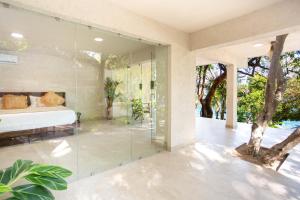a glass room with a bed and a glass wall at Corrales Bay Resort in Corrales +2 photos
