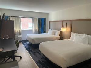 a hotel room with two beds and a desk at Comfort Inn Downtown Charleston in Charleston