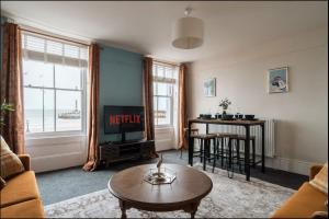 マーゲイトにあるMargate Bliss 3 Bed House with Beach Viewsのテレビとテーブルのあるリビングルーム