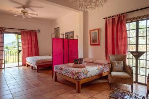 a room with two beds and pink furniture in it at Casa de Hospedaje Jardin del Tuito in El Tuito +74 photos