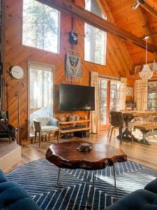 ein Wohnzimmer mit einem TV und einem Tisch in einer Hütte in der Unterkunft Cozy Chic Chalet - Enchanting & Fun Family Retreat - Hot Tub & Fire Pit - Dog Friendly in Dorrington