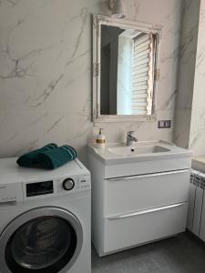 a bathroom with a washing machine and a sink at Apartamenty na Maja - 3 in Skierniewice +5 photos