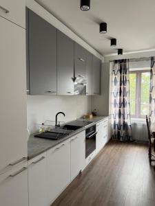 a kitchen with white cabinets and a counter top at Apartamenty na Maja - 3 in Skierniewice