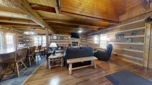 a living room with a couch and a table and chairs at Dogwood Acre cabin in Little Cove
