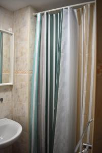 a bathroom with a shower curtain and a sink at Pension Urries  +67 photos