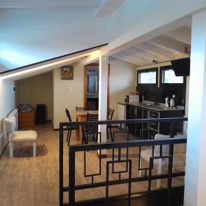 a room with a balcony with chairs and a kitchen at ARWEN Suites 1 in Trevelin