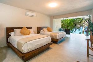 a bedroom with two beds and a balcony at Corrales Bay Resort in Corrales