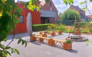 a garden with two benches and a white umbrella at Vakantiewoning De Schuur Tienen in Tienen
