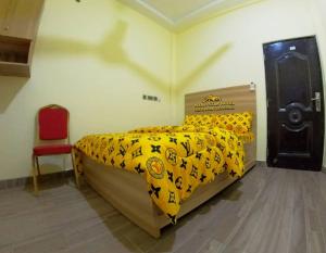 a bedroom with a bed and a red chair at Nyaji Star Hotel, Tamale in Trofwi