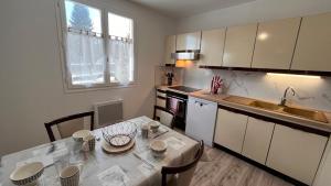 a kitchen with a table and a sink and a counter at La Parenthèse in Longchaumois