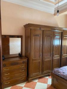 Oued LaouにあるAppartement Oued Laou resisendence Assalem, en bord de merのベッドルーム(木製キャビネット、鏡付きドレッサー付)