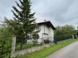 a white house with a fence and a tree at The Old Walnut House in Terziysko