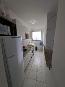 a white kitchen with a refrigerator and a sink at Apto Familiar in Aracaju