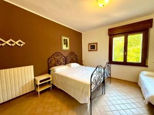una camera da letto con due letti e una finestra di Villa Lilly - 20 min da Maranello a Serramazzoni