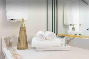 a bathroom with towels on a counter next to a mirror at NEW! Spacious Art Deco Modern 5 BD/3BA Condo in Chicago +49 photos
