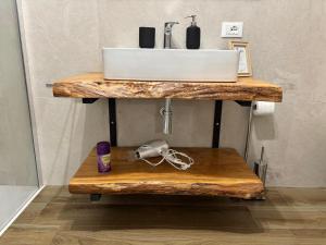 Un lavabo de baño encima de un estante de madera en Eccelsa 98, en Tívoli