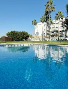 a large pool of blue water in front of a building at Petite Paradise Oliva in Oliva