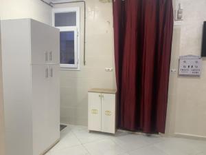 a bathroom with a red curtain next to a door at Appart Élégance Oran Centre in Oran