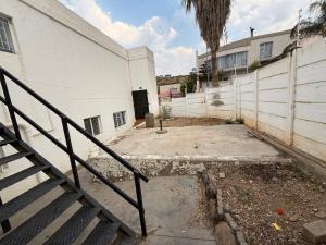 a stairway leading to a white building with a gate at Giribes House Number 1 Kleine Kuppe in Windhoek