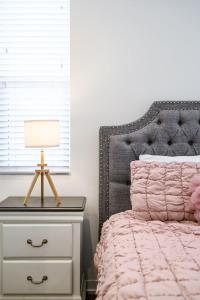 ein Schlafzimmer mit einem Bett mit einem Nachttisch und einer Lampe in der Unterkunft Central Location Cozy Private Bedroom w Bathroom in Irvine