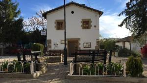 a white building with a fence in front of it at Hostal Urries Restaurante in Urriés