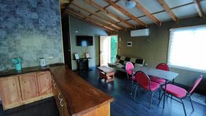 a living room with a table and pink chairs at cabañas mañio melipeuco in Melipeuco