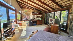 a living room with a person laying on a bed at Mirante do Leo - Casa com Piscina Aquecida e Loft Exclusivo com Vista para o Mar in Ubatuba