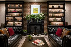 ein Wohnzimmer mit schwarzen Ledersofas und einem Kamin in der Unterkunft Arthouse Hotel in New York + 54 Fotos