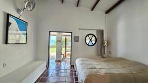 a bedroom with a bed and a clock on the wall at Mirante do Leo - Casa com Piscina Aquecida e Loft Exclusivo com Vista para o Mar in Ubatuba +65 photos