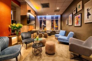 a waiting room with couches and chairs in a hospital at Leonardo Hotel Amsterdam City Center in Amsterdam