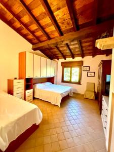 una camera da letto con due letti e soffitto in legno di Villa Lilly - 20 min da Maranello a Serramazzoni