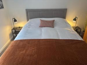 a large bed with a red pillow on it at New City Centre Flat No 1 2 Bedrooms Free Parking in Leicester