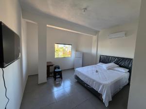 a bedroom with a bed and a desk and a television at Departamentos Imperial in Encarnación