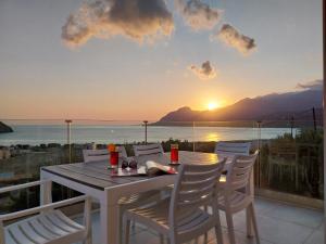 a table and chairs on a balcony with a view of the ocean at Villa Evriali in Plakias