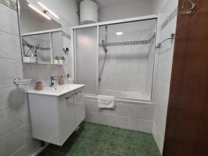 a white bathroom with a shower and a sink at TIZA Apartments in Vantačići +58 photos