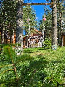 a swing hanging from two trees in a yard at Forest House A Frame in Risovac