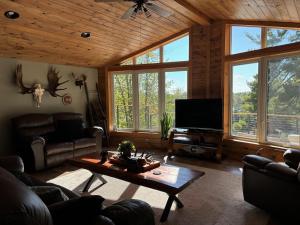 フォートフランシスにあるPeaceful Year Round Lakefront Getaway Nickel Lakeのソファとコーヒーテーブルのあるリビングルーム