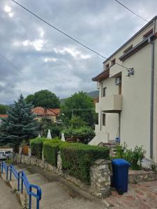 a white house with a blue fence next to it at APARTMANSKI SMEŠTAJ SOLARIS kod Aqua Parka STUDIO APARTMANI in Soko Banja