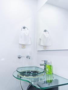 a glass sink in a bathroom with white walls at Apt Platinum Rodadero 9C in Estación El Salto +25 photos