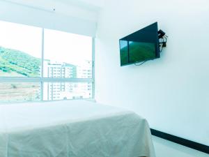 a bedroom with a bed and a tv on the wall at Apt Platinum Rodadero 9C in Estación El Salto